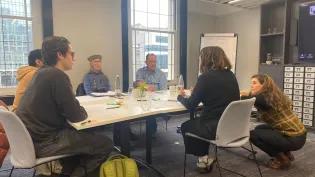 Members of the Citizen Panel Workshop sitting around a table having a discussion