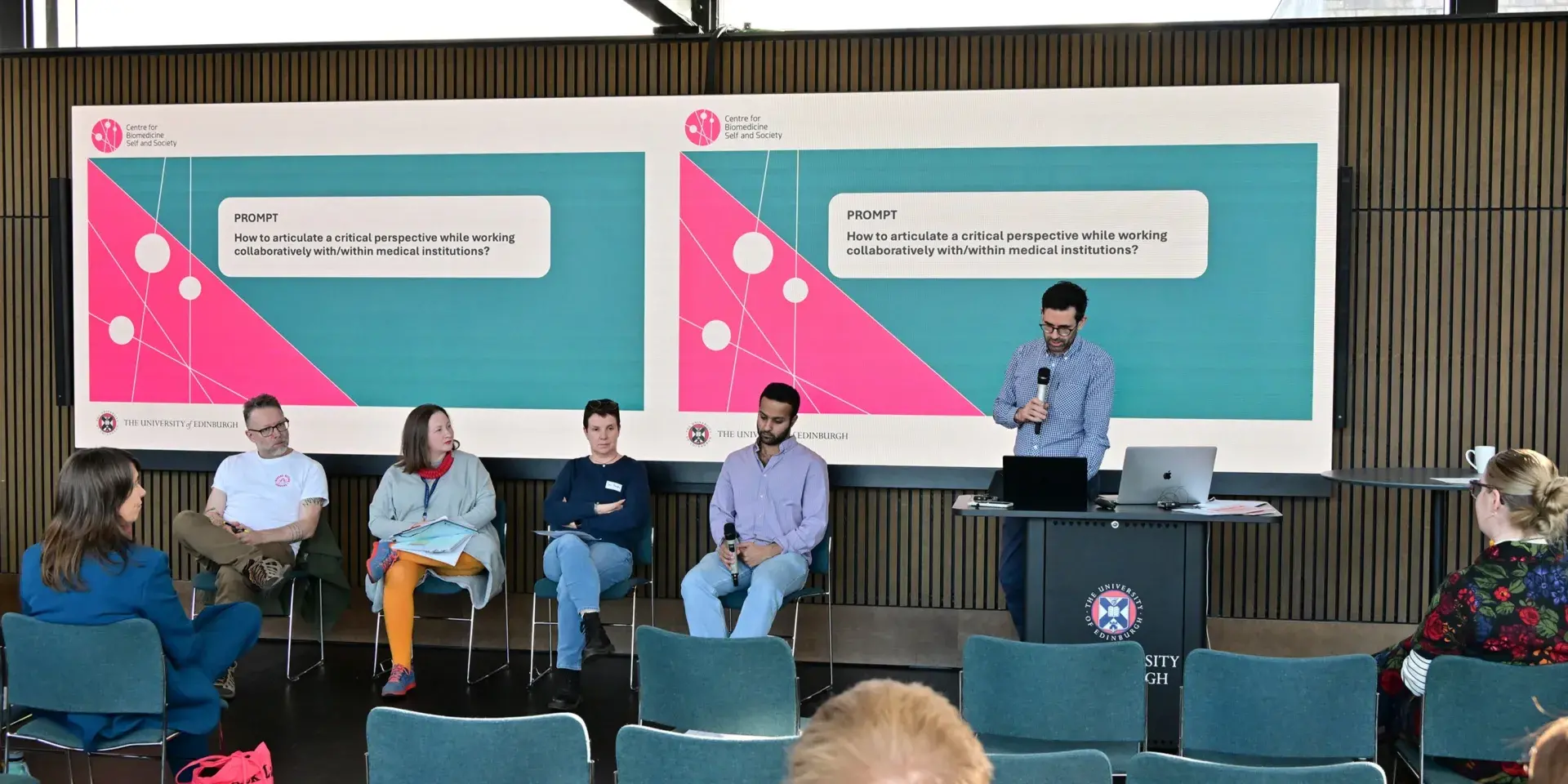 Lukas Engelmann introduces the panel, prompt on slide behind says 'How to articulate a critical perspective while working collaboratively with/within medical institutions.'