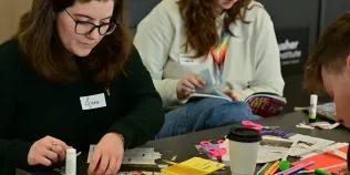 Two participants browse magazines and create collages.