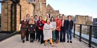 A group of people pose together on a rooftop terrace.