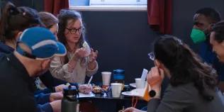 A group take part in a workshop, holding up objects and discussing them