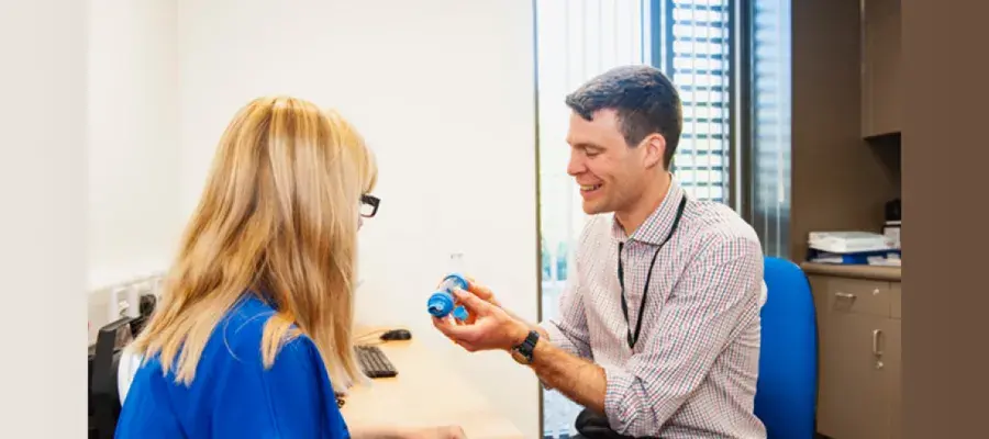 GP demonstrating the use of a spacer to an asthma patient