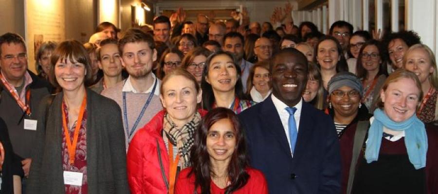 Photo of a group of students, staff and alumni smiling 