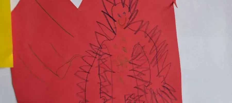 A child's drawing of a man-shaped monster with a speech bubble written in Polish.
