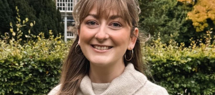 An image of a woman smiling in front of an Edinburgh University building