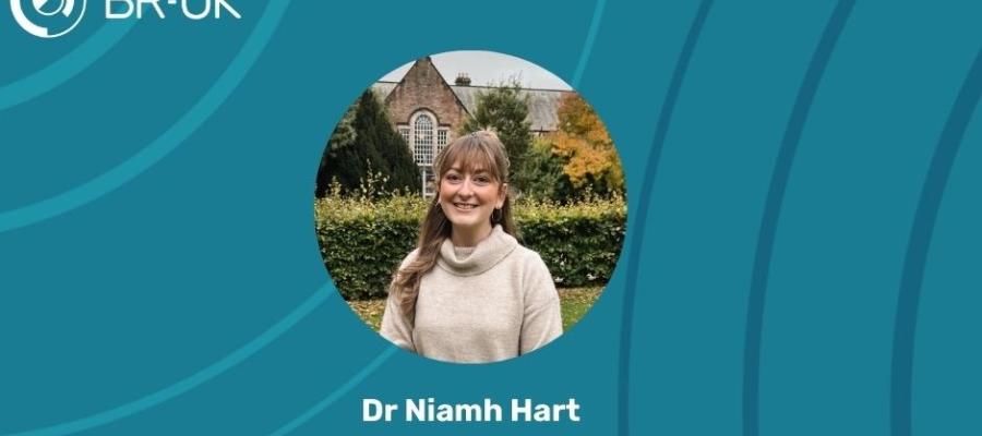 An image of a woman smiling in front of an Edinburgh University building