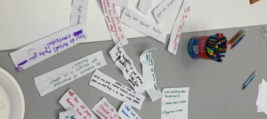 Paper slips with questions about periods on them.