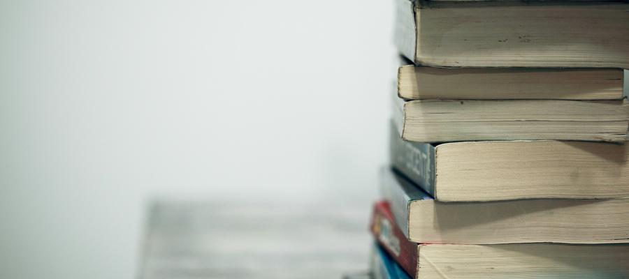 Assorted books on a wooden table.