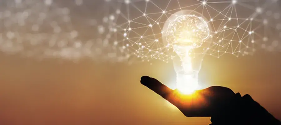A brain inside a light bulb, shining a light onto a web of data points.
