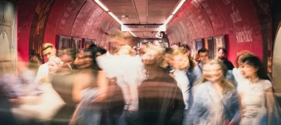 A crowded subway tunnel full of moving people.