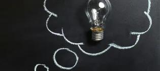 Clear Light Bulb Placed on Chalkboard
