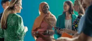 Candid photo of people chatting against a blue/green background