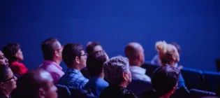 An image of people sitting in rows at an event.