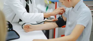 Doctor measuring blood pressure of a boy at the hospital