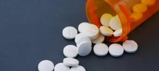 Photograph of a bottle spilling pills