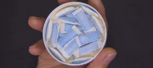 circular tin containing tobacco pouches