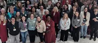 Photo of a group of students, staff and alumni smiling
