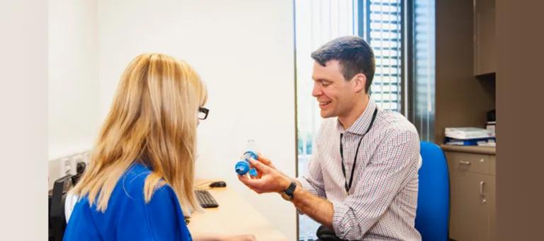 GP demonstrating the use of a spacer to an asthma patient