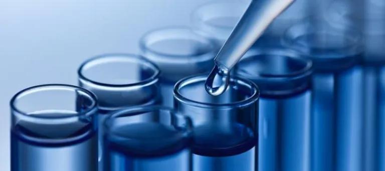 Picture of lab tubes with a dropper hovering over one