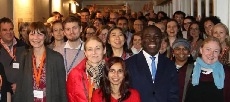 Photo of a group of students, staff and alumni smiling 