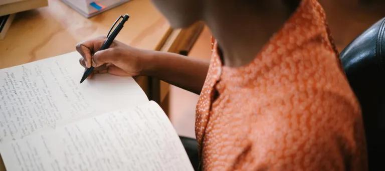 person writing in a book