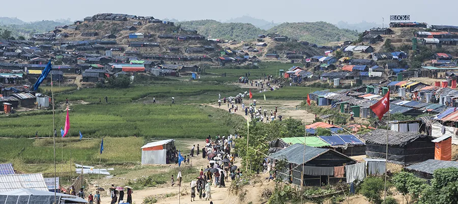 Rohingya Muslims walk down a dirt lane in the crowded Jamtoli refugee camp near Cox's Bazar, Bangladesh