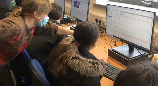 Children and teacher using computer for data science