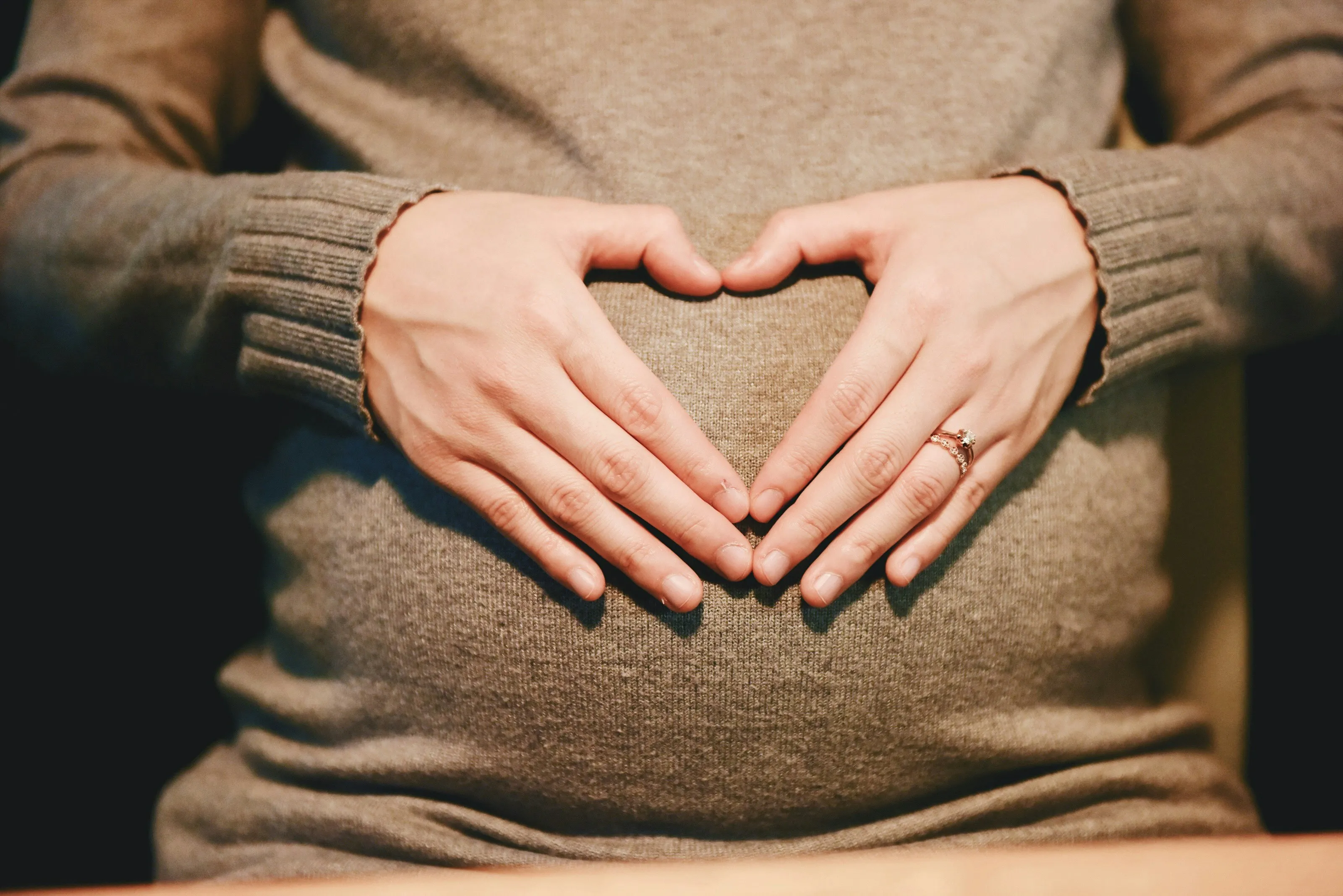 Pregnant women making a heart shape with her hands