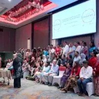 A speech being presented to a group of people stood on a stage