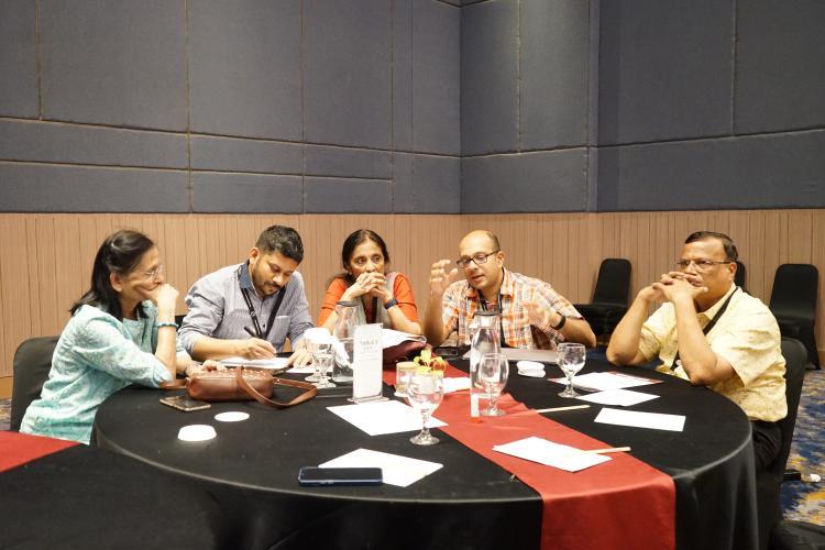 5 people having a discussion at a table