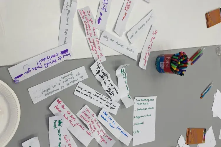 Paper slips with questions about periods on them.