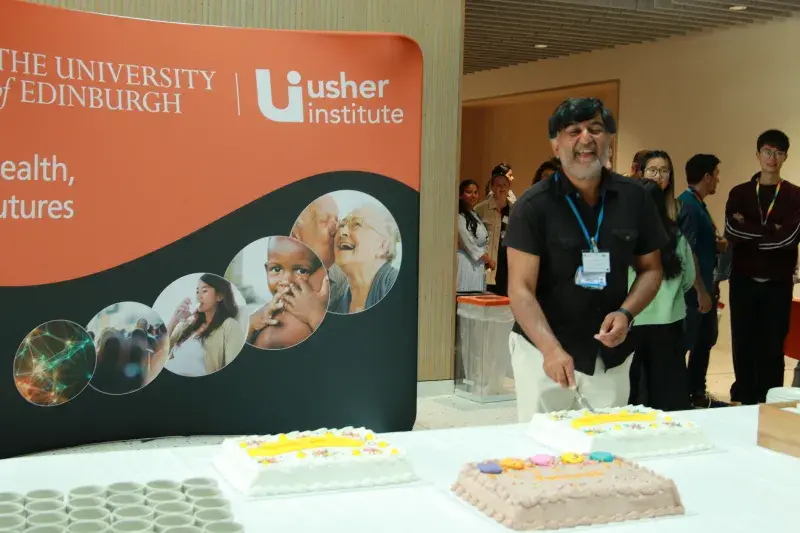 Professor Sir Aziz Sheikh OBE cutting his farewell cake at the June 2024 Usher Forum