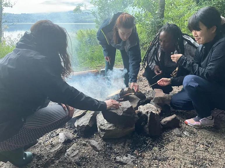 A group of PhD students sitting around a campfire at Firbush