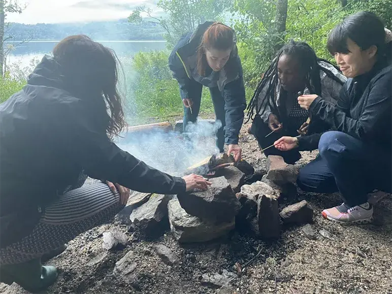 A group of PhD students sitting around a campfire at Firbush