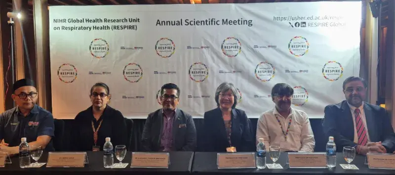 Six people sitting on a press conference panel