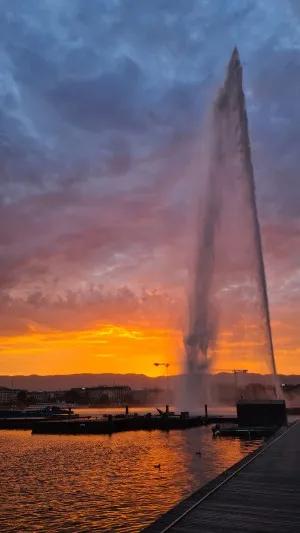 A fountain of water at sunset over Lake Geneva