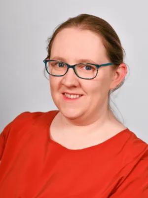 Headshot of Dr Charlene Redmond wearing a bright red shirt
