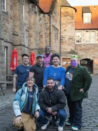 A group of people pose together in a courtyard.