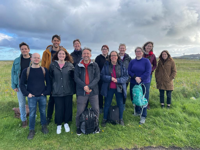 12 people posing for the camera in a field