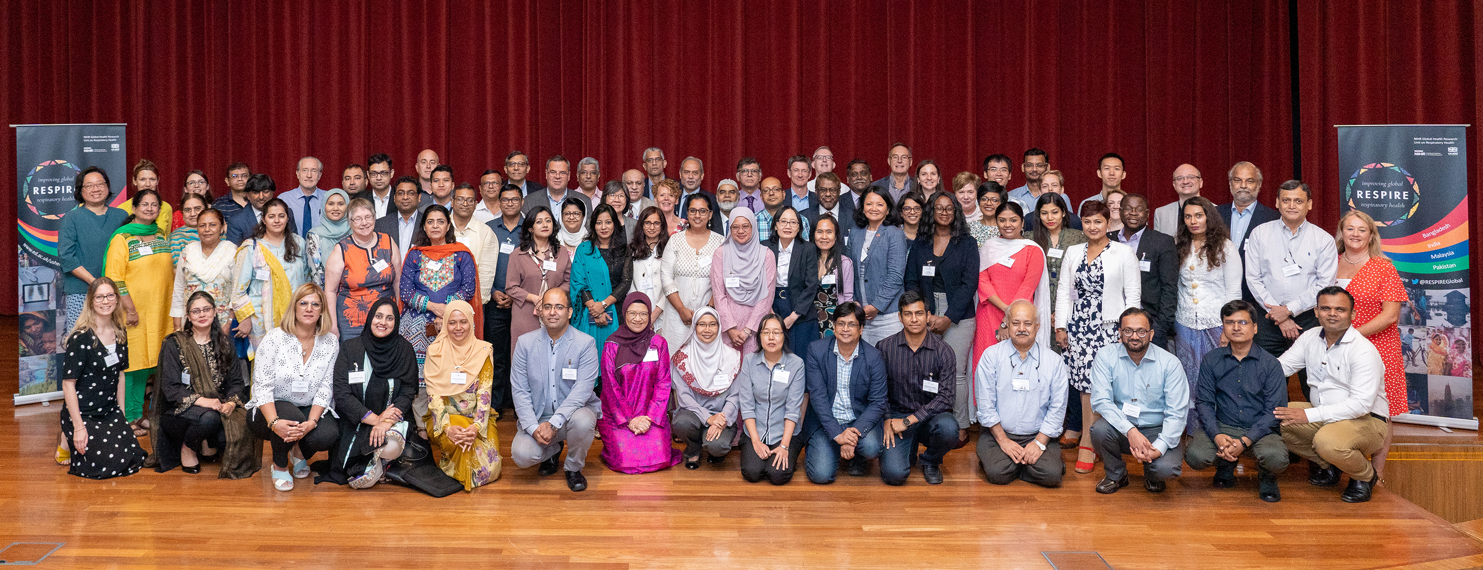 RESPIRE members group photo on stage next to roller banners