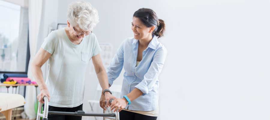 Older lady with walking frame and helper